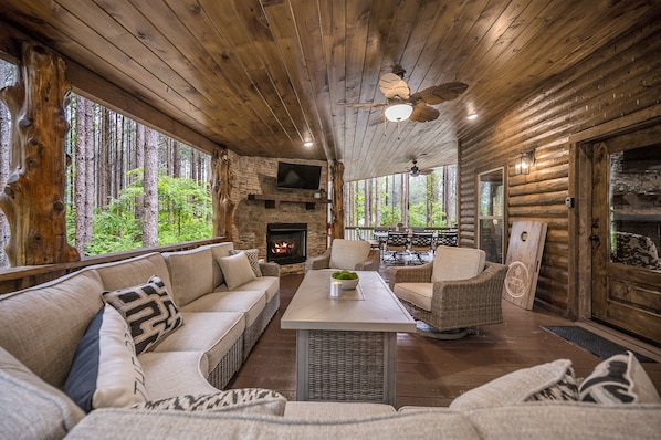 Relax on the large back patio featuring a smart TV over a gas fireplace.
