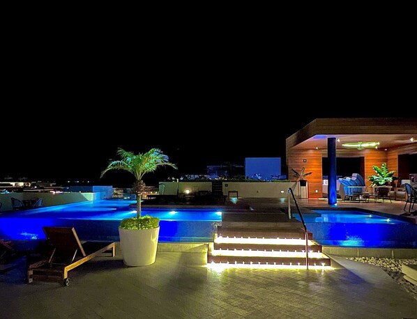Rooftop infinity pool with 360 degree views at night