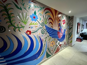 The folklore style mural of Mexican birds, agave & flowers fills the hall.