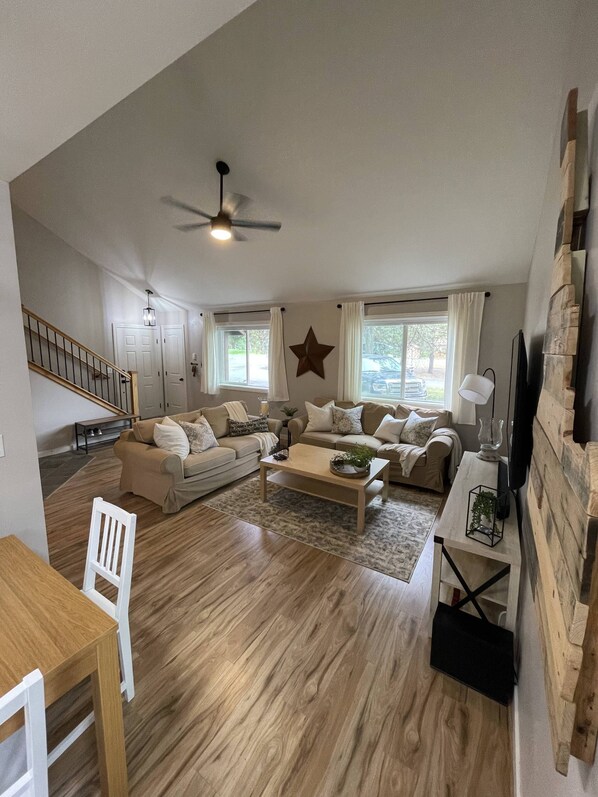 Living space with 65 inch smart TV, pullout bed, and 2 couches.