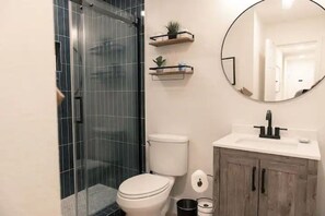 Fully remodeled and stylish bathroom with frameless glass and hair dryer