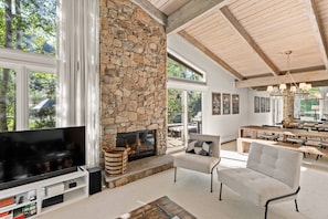 The vaulted ceilings and floor to ceiling windows bring the outdoors inside the open living space.