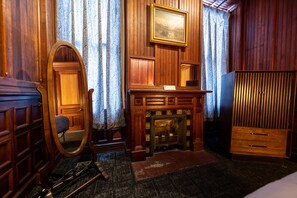 he Byers' Suite bedroom is ornamented with a mirror, dresser, and ceiling fan.