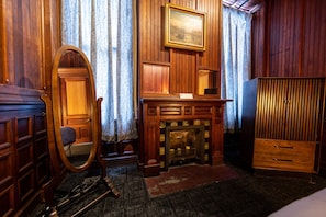 he Byers' Suite bedroom is ornamented with a mirror, dresser, and ceiling fan.