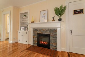 Cozy up around the fireplace just off the kitchen.