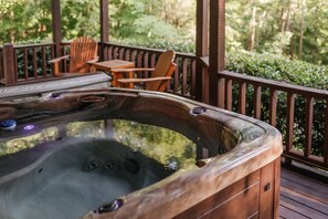 Hot tub on lower deck with forest views