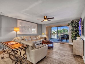 Living room with view of lake with fan and Roku tv