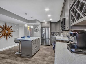 Full size kitchen with plenty of dishes, glasses and cooking pots and pans