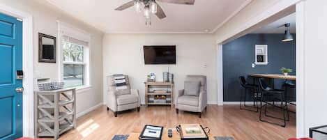 The living room has two recliners and a sofa, providing ample seating for up to 4 guests. A desk behind the couch offers a space to work, if needed.