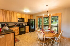 Kitchen and Dining with Glass Door Leading to the Deck