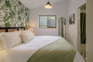 Primary bedroom with a queen Helix Hospitality mattress and hotel-quality bedding for a restful night’s sleep.