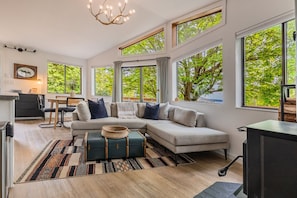 Relax in the cozy living room flooded with natural light from wall-to-wall windows.