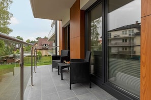 Furnished balcony with green surroundings. 