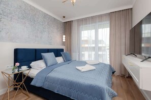 Another bedroom with a neatly made queen-size bed, soft lighting, and matching bedside tables. The room’s calm colors and decor exude comfort.
