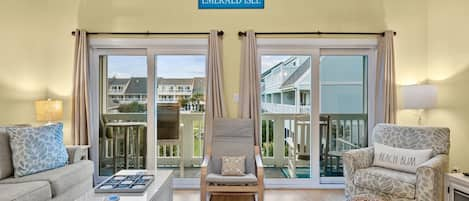 Family room with vaulted ceilings and double sliders out to large balcony