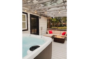 Hot tub, seating area, and fire pit on guest house deck
