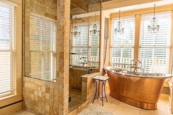 Immaculate master bathroom with walk-in shower with body jets and a copper soaking tub.