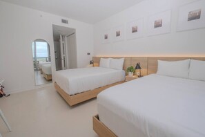 Two cozy full-size beds, a private bathroom, and a kitchenette make this second bedroom a perfect space for extra guests at Beachwalk, Hallandale Beach.