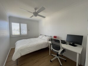 Second bedroom upstairs with work from home desk, office chair, and monitor