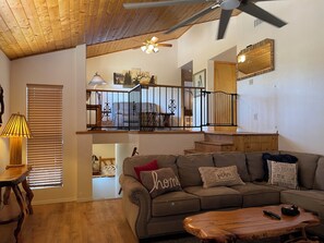 Formal living room looking up to loft area and a view down to the basement 