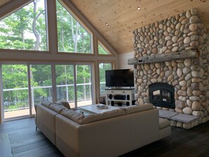 The great room has a walk-out deck, smart TV and wood fireplace 