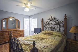 queen size bed in master bedroom looking to dresser and bathroom door