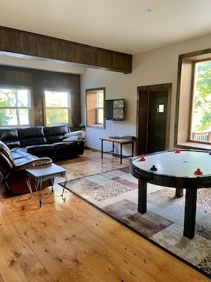 Recreation room with TV for videos, large reclining sectional and air hockey. 