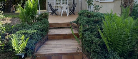 Vue de la terrasse en été. Avec des accès sur le salon et la cuisine, pratique.