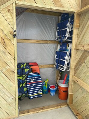 Beach Toy Closet with sand toys, boogie boards, corn hole, and beach chairs. 
