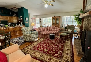 The living room features and array of seating, all with cozy cottage charm
