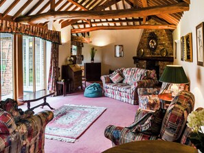This is the largest room in the house, plenty of comfortable seating areas a library, TV and a woodburning stove | Lodge Farm Barn, South Walsham