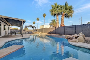 Backyard oasis with crystal clear pool, waterfall, covered patio, and gazebo