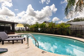 Heated pool with lounge chairs and pool floats for a relaxing afternoon.