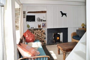 Ground floor: Front room with vintage sofa, cosy burner and Barney Dog clock