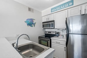 The full kitchen is fully equipped with all the amenities you need to feel at home, including a full-sized refrigerator, stove, microwave, and more.