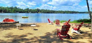 Beach with chairs, tables, raft and paddle boat for all to enjoy!