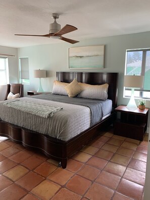 Master bedroom. King bed. Sitting area and door open to back balcony. 