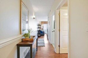 Hallway leading to the bedroom, bathroom, open living room/kitchen, and balcony directly across from the Battleship.
