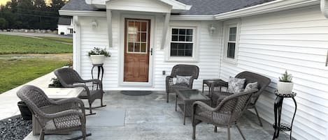 Main entrance to the home.  Patio with comfortable furniture and a fire table