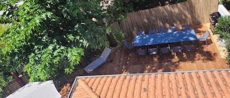 Coin repas et parasol à côté de l'entrée de la piscine