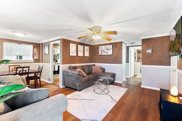 This view is from the entrance, open layout with a large living room, dining area and kitchen to the left, and to the right you will find both bedrooms and the bathroom.