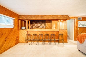 Relax in the basement living room, which features a large, comfortable couch and a stylish bar. It's an ideal space for socializing, entertaining, or simply unwinding after a day of activities.