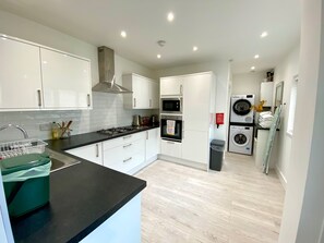 Bright spacious kitchen with microwave, hob, oven, fridge, utensils and pans. 
Self-catering laundry area with iron and ironing board. 