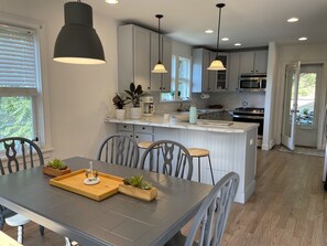 Spacious kitchen seating area - table sits 6 with 2 stools at the bar.