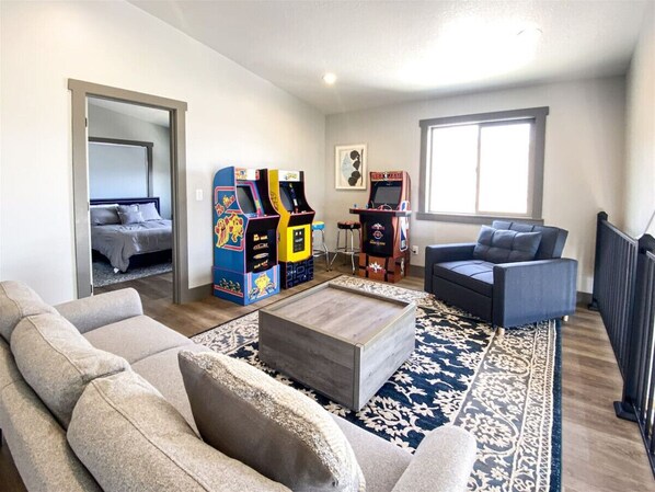 Fun-filled arcade lounge with retro games and cozy seating—perfect for relaxing or friendly competition.