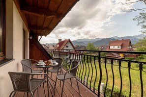 A balcony view showcasing a scenic neighborhood with mountains in the background.