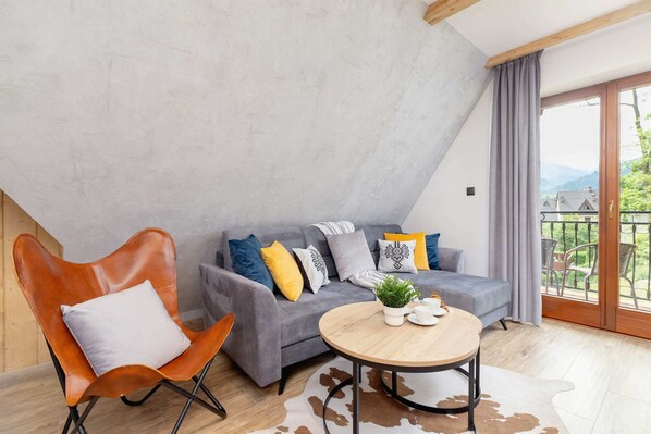 A cozy living room with a modern gray sofa, a wooden coffee table, and a stylish lamp.