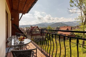 A balcony view showcasing a scenic neighborhood with mountains in the background.