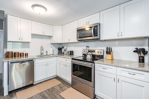 Fully-stocked kitchen with a stove/oven, and microwave