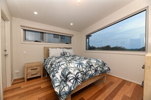 Bedroom 1 - Queen bed with sunrise views over the Prom.